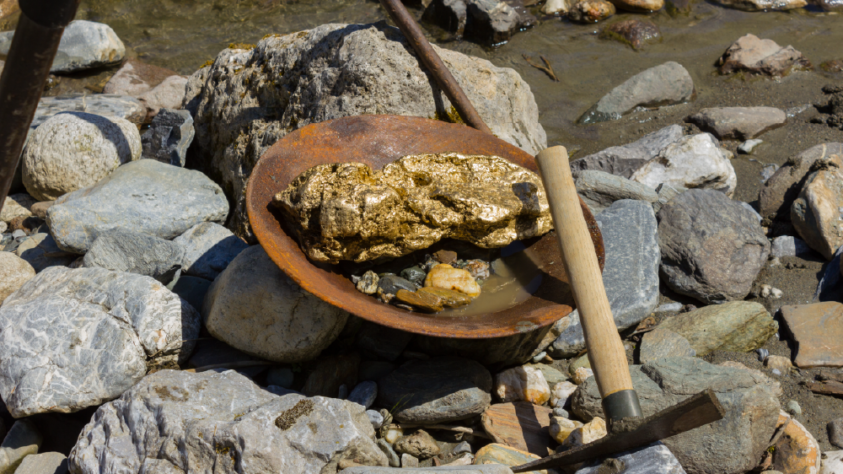 gold in a bowl with a pick axe