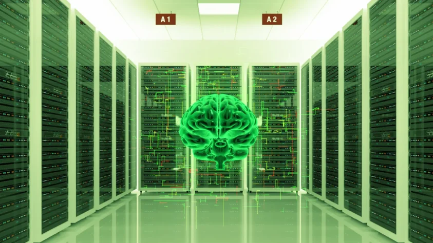 A glowing green brain surrounded by walls of mainframe hardware