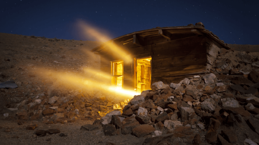 wooden entrance to a gold mine, with bright golden light shining out of it