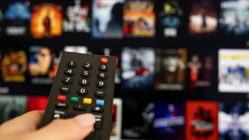 TV remote pointed at a TV, scrolling through Netflix