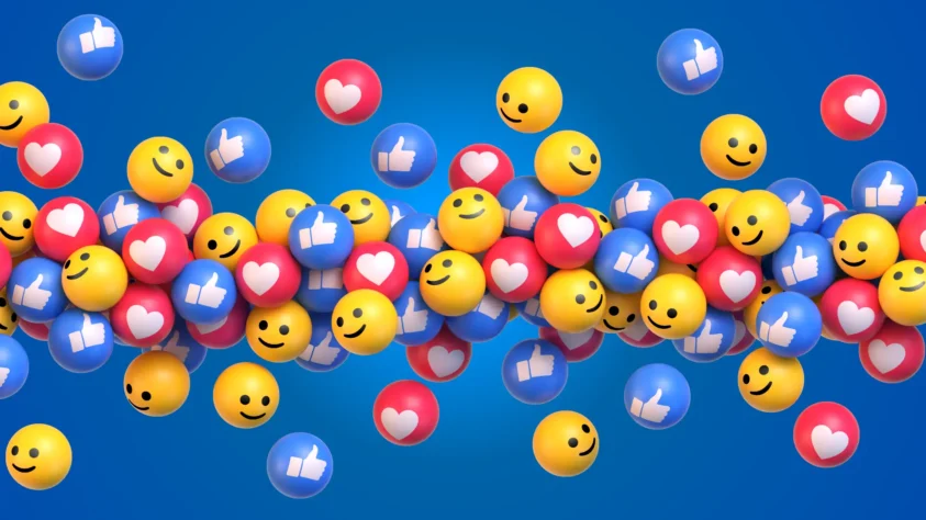 A mixed group of balls, each one either being a Facebook like button, heart button, or smiley face button.