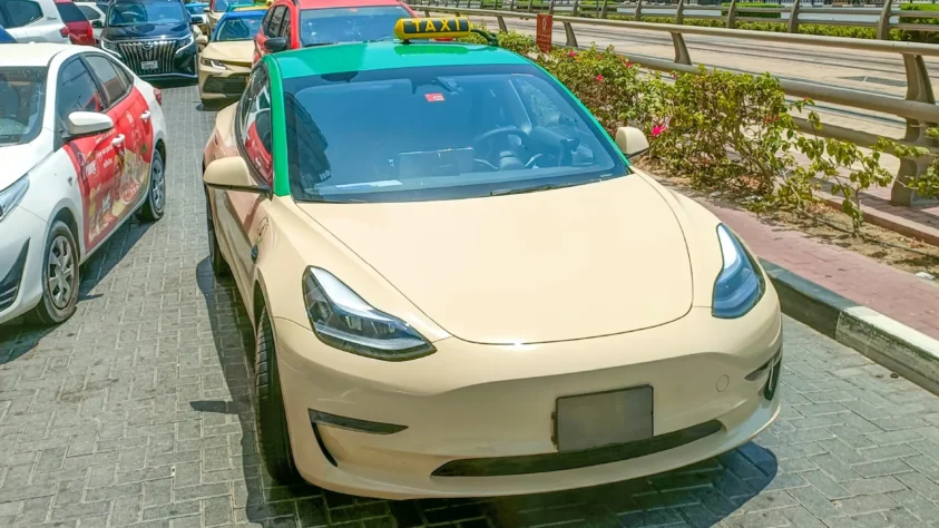 Cream colored Tesla car with a green roof